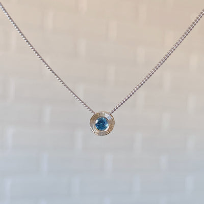14k white gold small aurora necklace with a blue montana sapphire center 