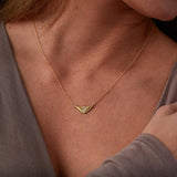 Triangular gold flash necklaw eith a diamond center and sunburst carved motif in 14k yellow gold around a neck by Corey Egan