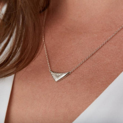 Triangle silver sunburst necklace with diamond center around a neckby Corey Egan