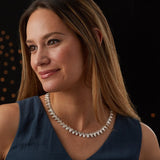 Sterling silver statement necklace made of triangular carved links with a sunburst design on a model | Corey Egan