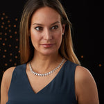 Sterling silver statement necklace made of triangular carved links with a sunburst design on a model alternate view| Corey Egan