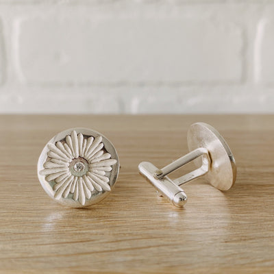 Side view sterling silver round cufflinks with a floral carved sunburst design and diamond centers