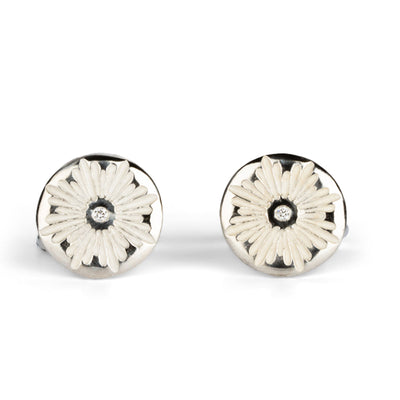 Sterling silver round cufflinks with a floral carved sunburst design and diamond centers on a white background