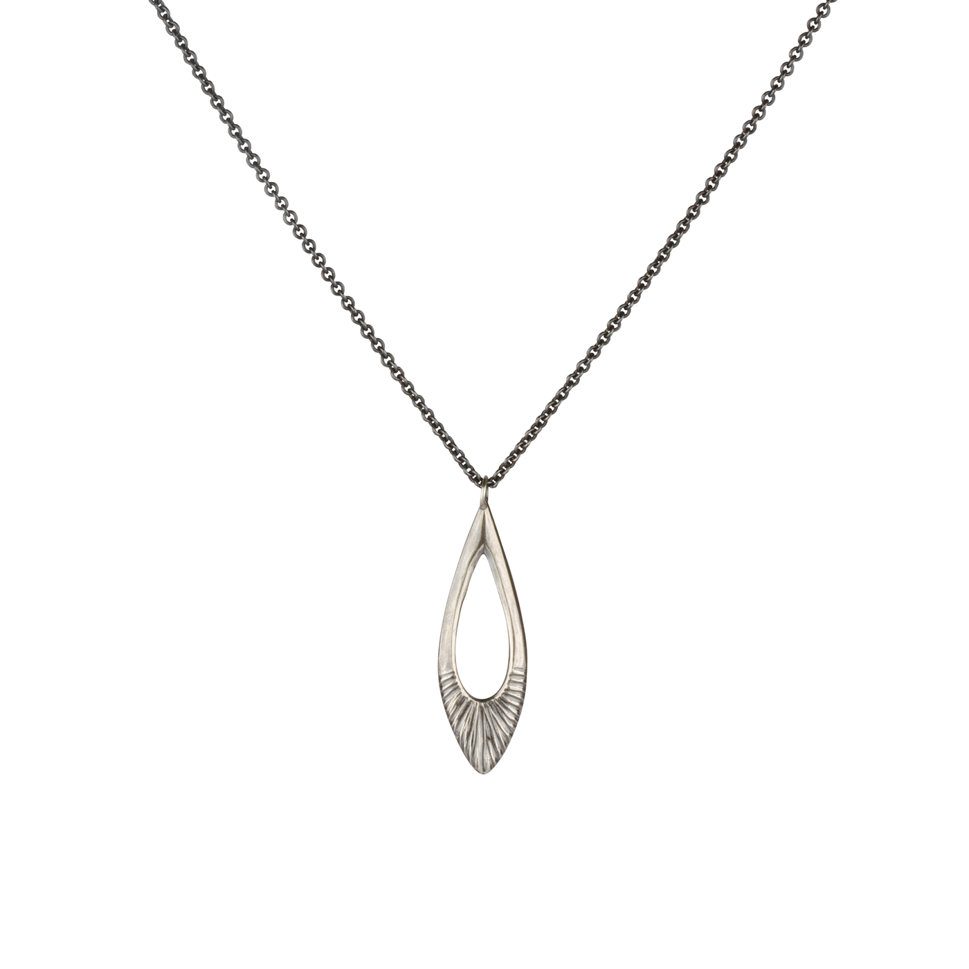 Oblong petal shaped pendant with a carved sunburst texture in oxidized sterling silver on a white background