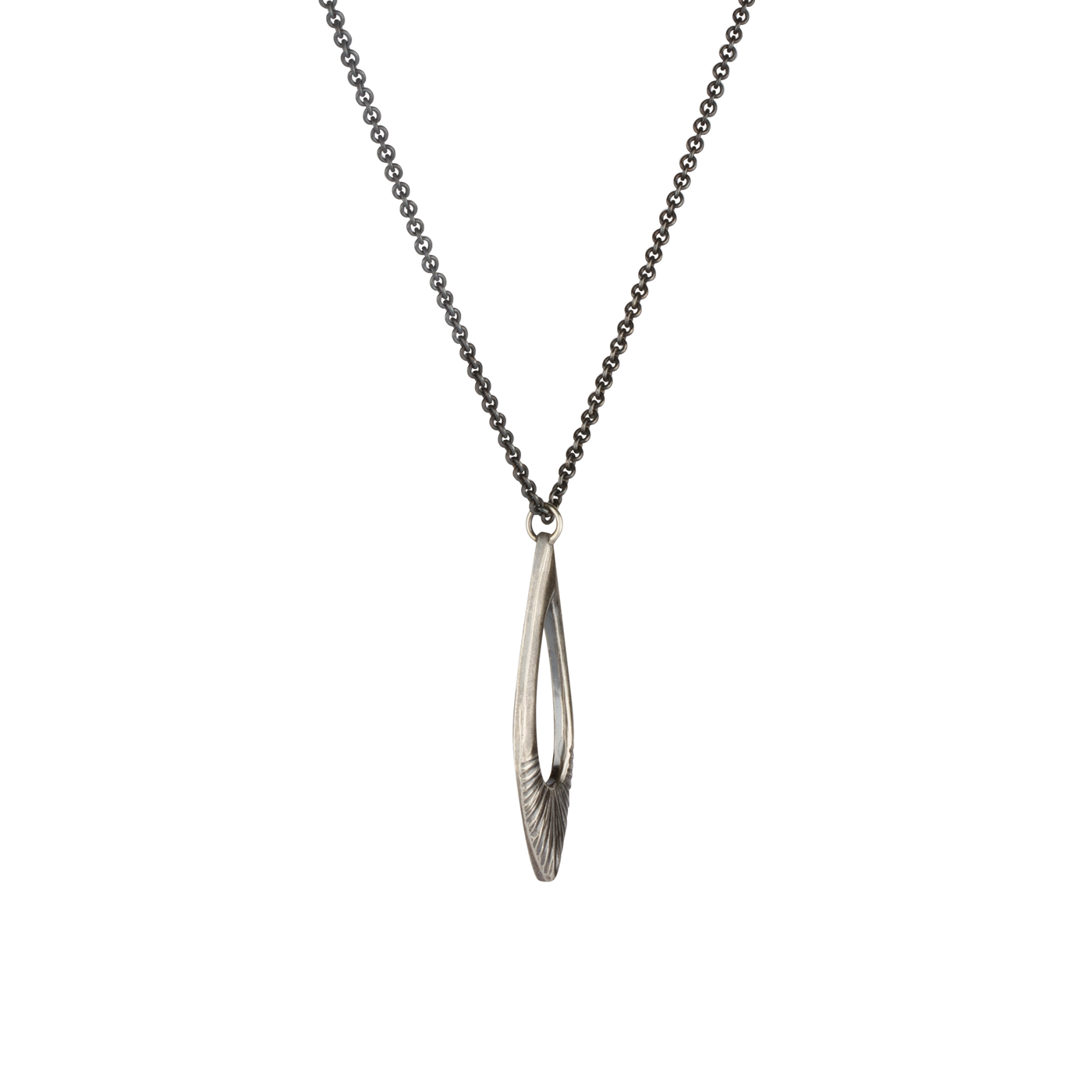 Side view of Oblong petal shaped pendant with a carved sunburst texture in oxidized sterling silver on white