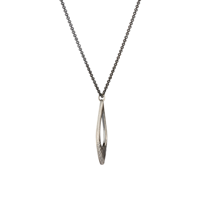 Side view of Oblong petal shaped pendant with a carved sunburst texture in oxidized sterling silver on white