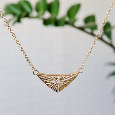 Triangular gold flash necklaw eith a diamond center and sunburst carved motif in 14k yellow gold. by Corey Egan