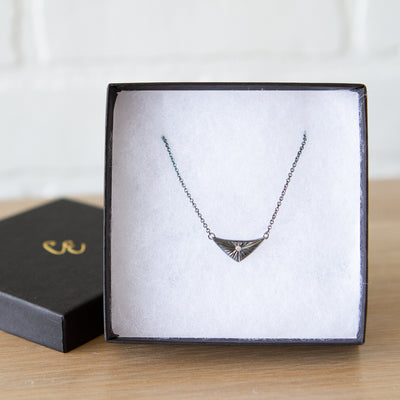 Triangle oxidized silver flash necklace with carved rays motif and a single center diamond in a gift box