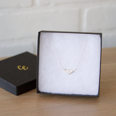 Triangle silver sunburst necklace with diamond center in a gift box by Corey Egan
