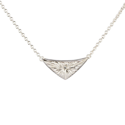 Triangle silver sunburst necklace with diamond center on a white background by Corey Egan