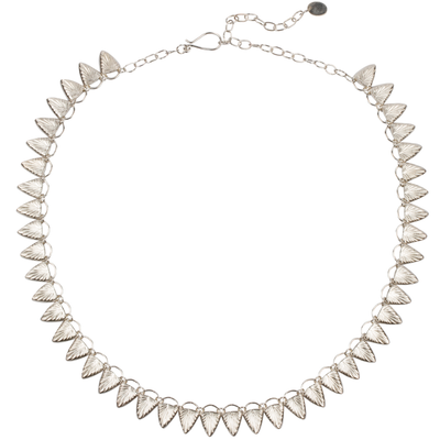 Sterling silver statement necklace made of triangular carved links with a sunburst design on a white background | Corey Egan