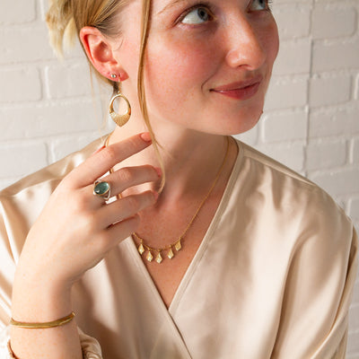 A model wearing the bronze Aura cuff with an aquamarine ring and vermeil jewelry