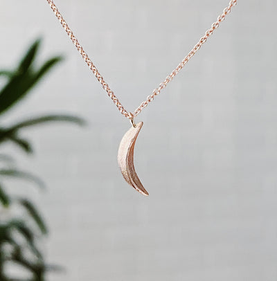 Rose Gold Small Wisp Moon Necklace by Corey Egan in natural light