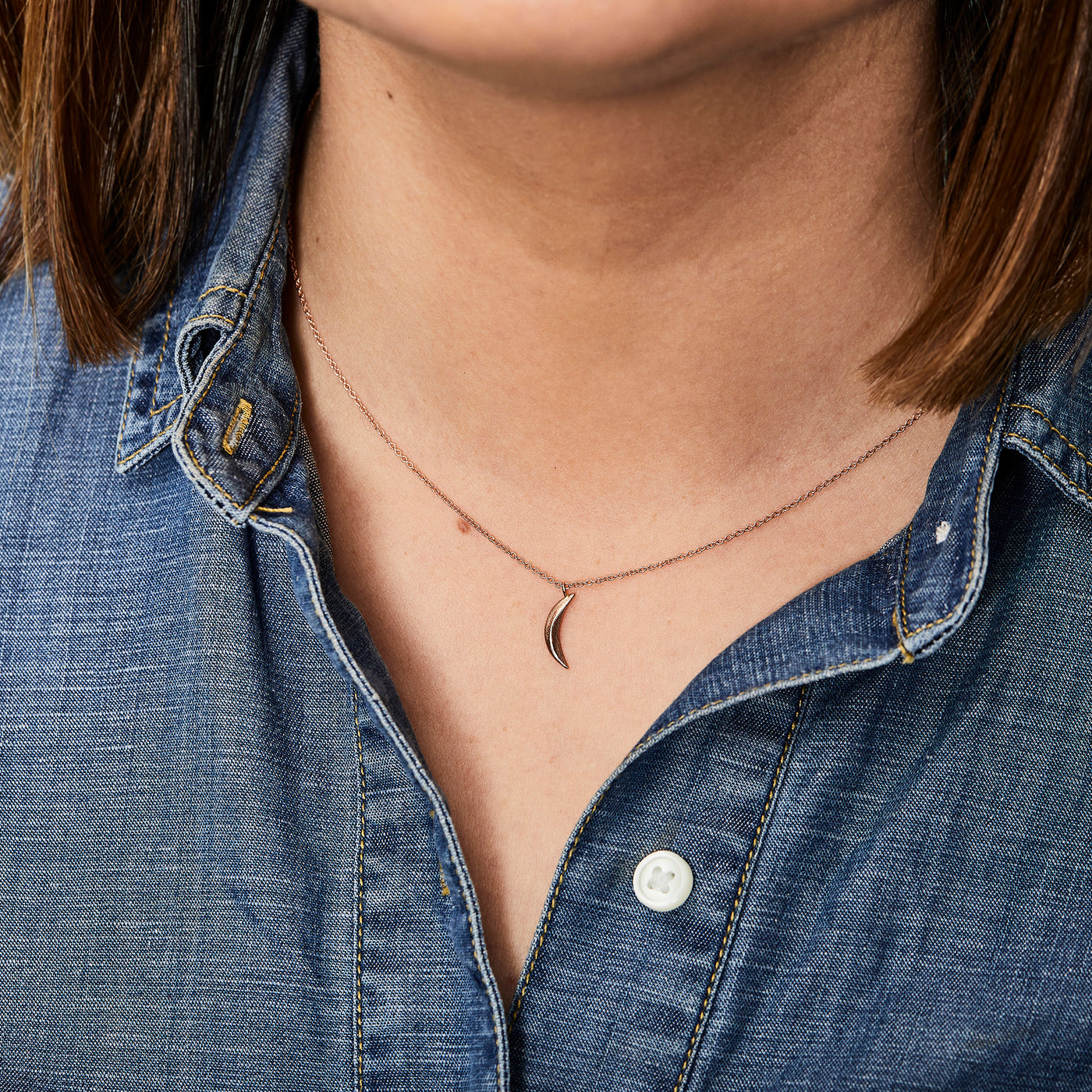 Rose Gold Small Wisp Moon Necklace by Corey Egan around a neck