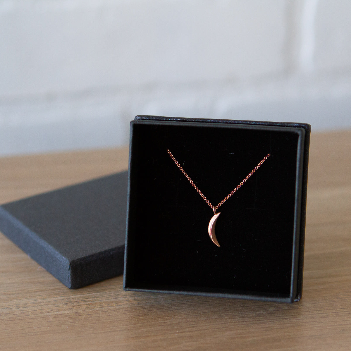 Rose Gold Small Wisp Moon Necklace by Corey Egan in a gift box