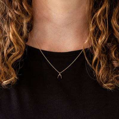 Rose Gold Wishbone Necklace around a neck