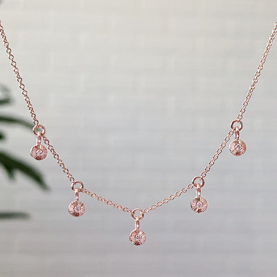 14k rose gold and diamond Rise station necklace by Corey EganRose gold and diamond station necklace with five tiny engraved pendants with diamond centers