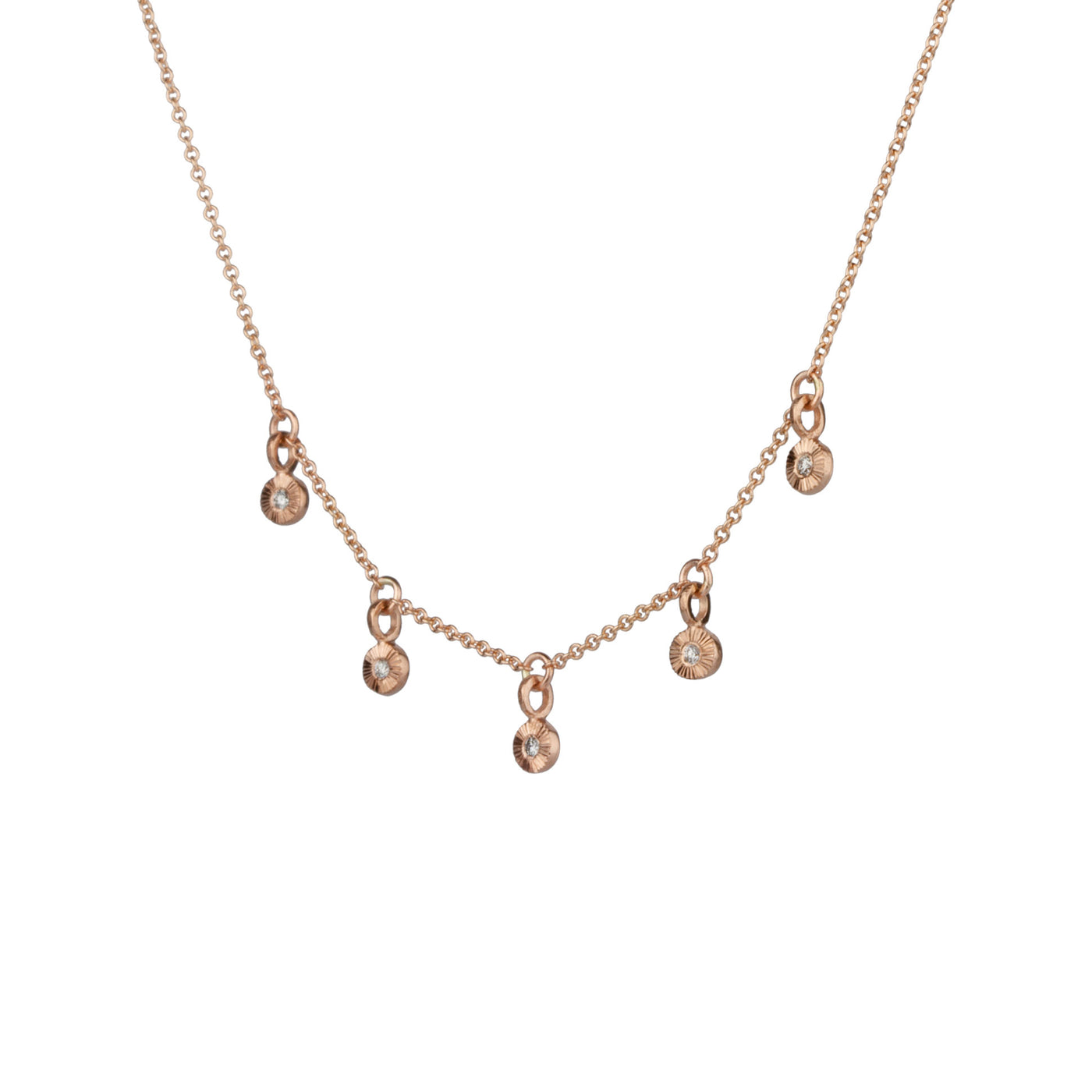 Side view Rose gold and diamond station necklace with five tiny engraved pendants with diamond centers on a white background