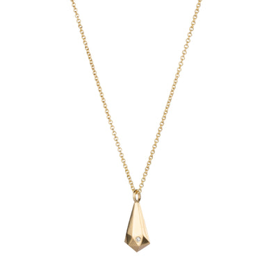 Side view of 14k yellow gold faceted crystal fragment pendant with a diamond and a gold chain on a white background 