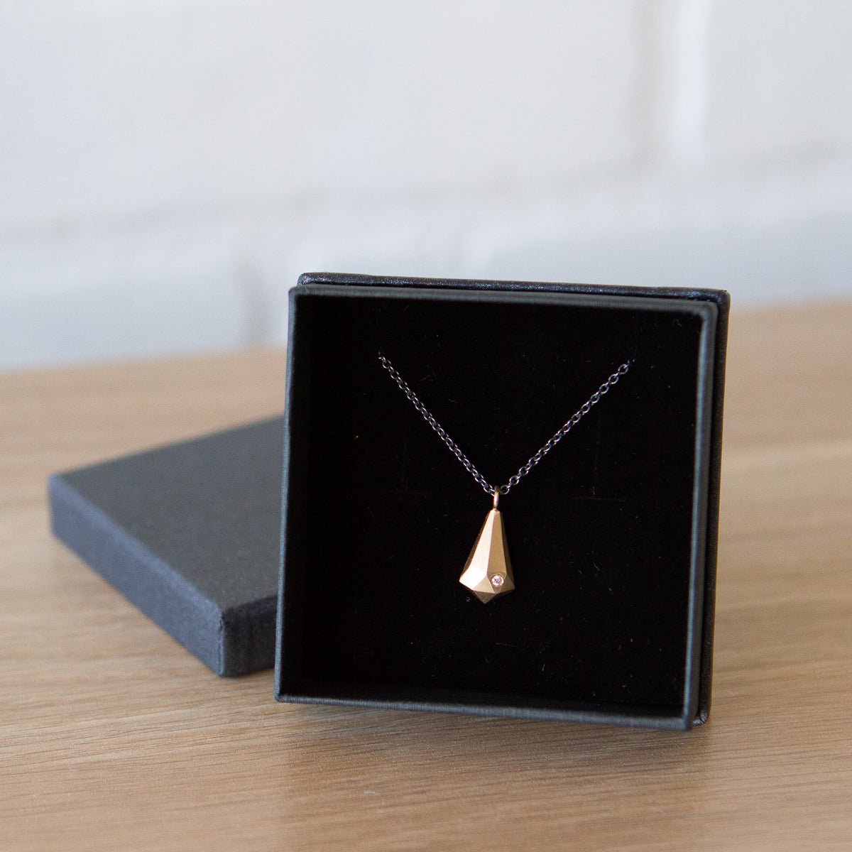 14k yellow gold faceted fragment pendant with a single diamond on an oxidized silver chain in a gift box