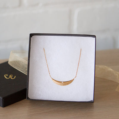 Crescent necklace with carved rays and a single diamond in vermeil  in a gift box