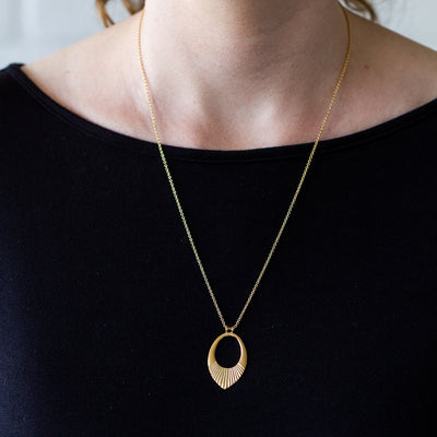 Gold vermeil medium open petal shape pendant with a textured bottom on a 22" chain around a neck
