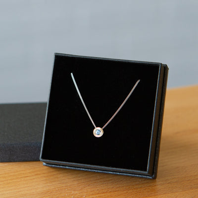 14k white gold small aurora necklace with a blue montana sapphire center in a gift box