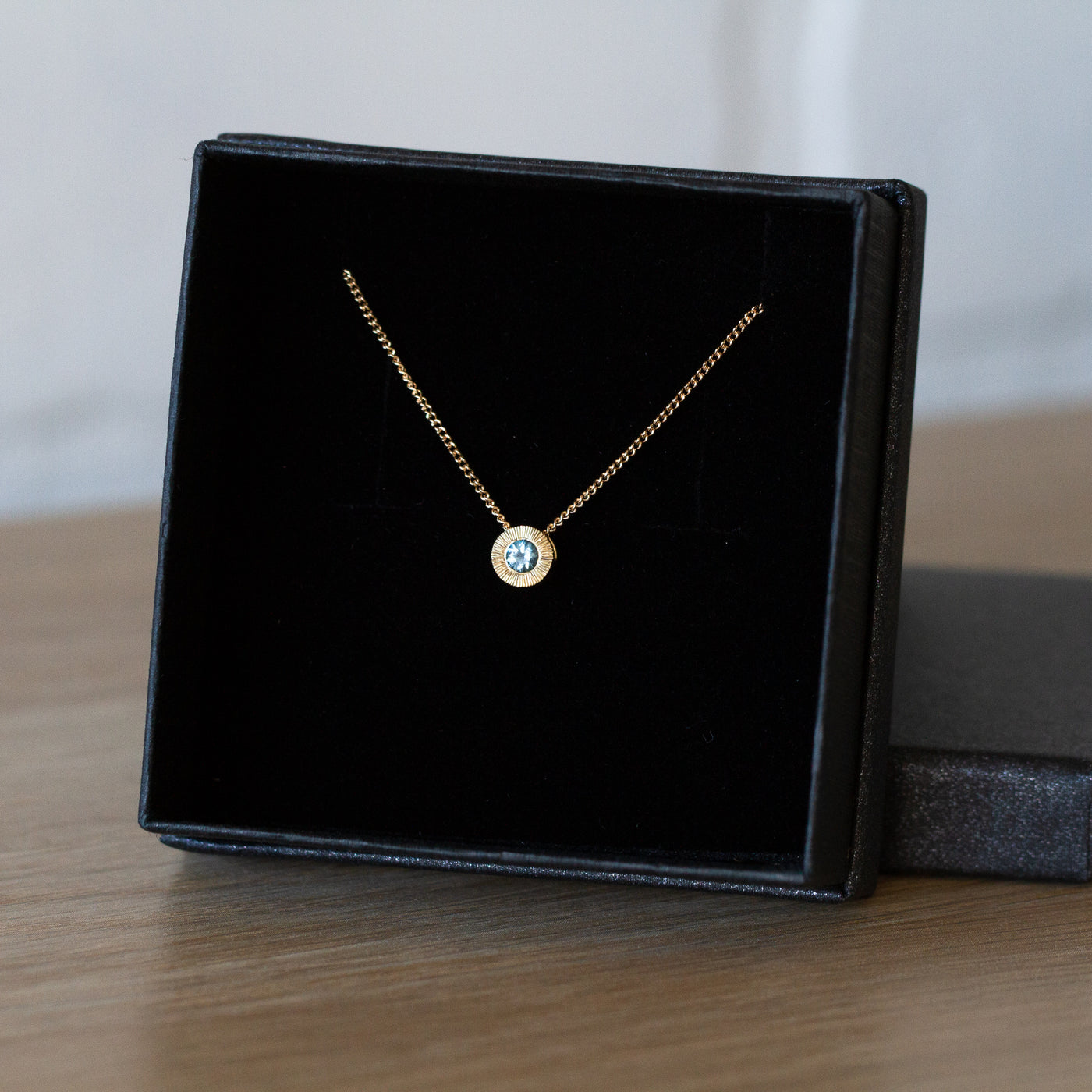 14k yellow gold small aurora necklace with a denim blue Montana sapphire center in a gift box