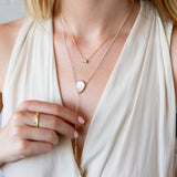 14k yellow gold aurora diamond necklace layered with a moonstone and gold selene larait on a model