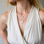 14k yellow gold aurora diamond necklace layered with a moonstone and gold selene larait on a model