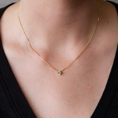 May birthstone Aurora slide necklace with emerald in yellow gold on a neck