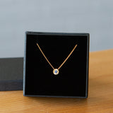 14k yellow gold small aurora necklace with a blue montana sapphire center in a gift box
