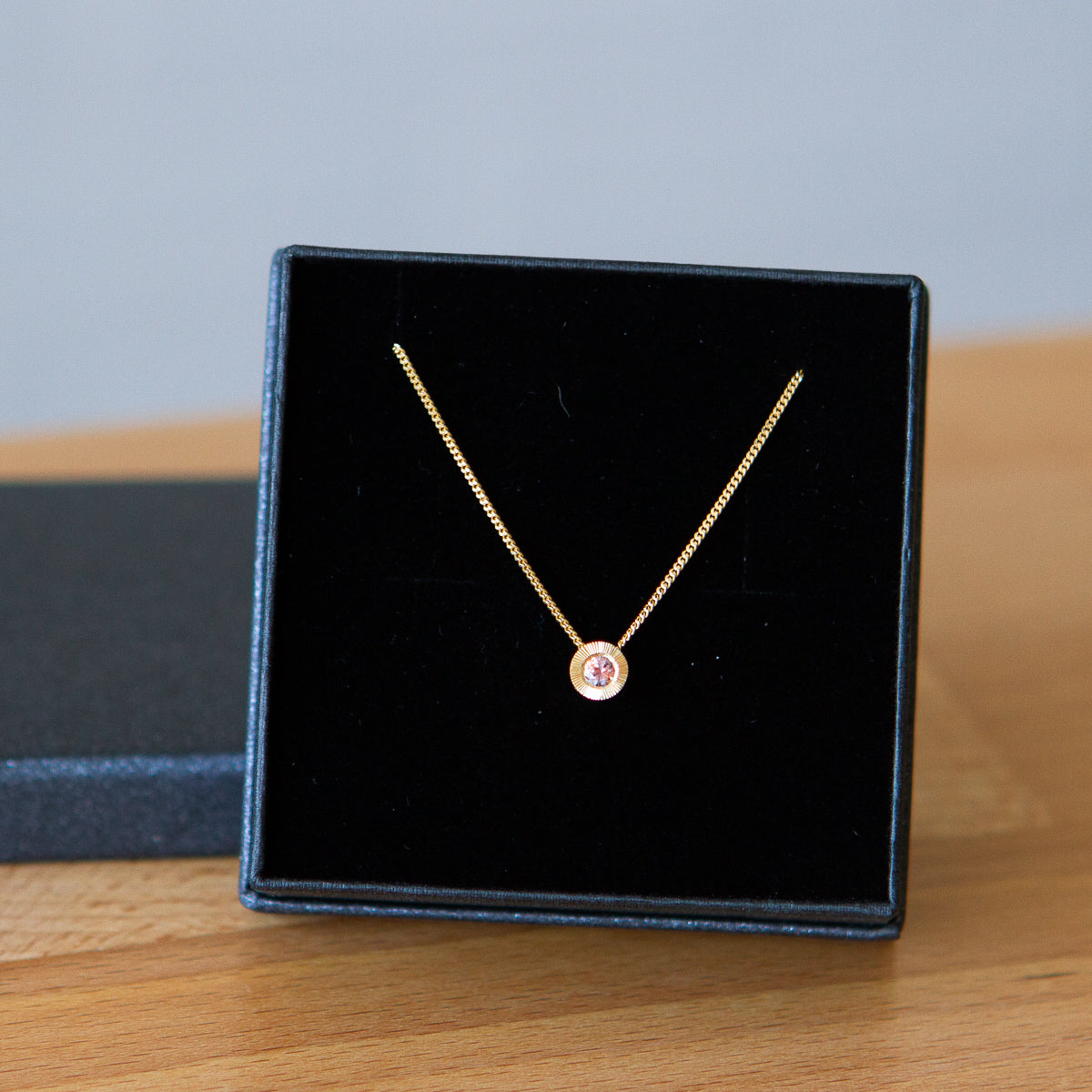 14k yellow gold small Aurora necklace with pink Montana sapphire center in a gift box
