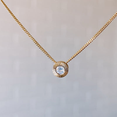 June birthstone 14k yellow gold Aurora necklace with moonstone center and engraved sunburst halo border.
