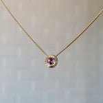 October birthstone 14k yellow gold Aurora necklace with pink tourmaline center and engraved sunburst halo border.