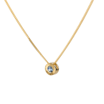 Side view 14k yellow gold small aurora necklace with a denim blue Montana sapphire center on a white background