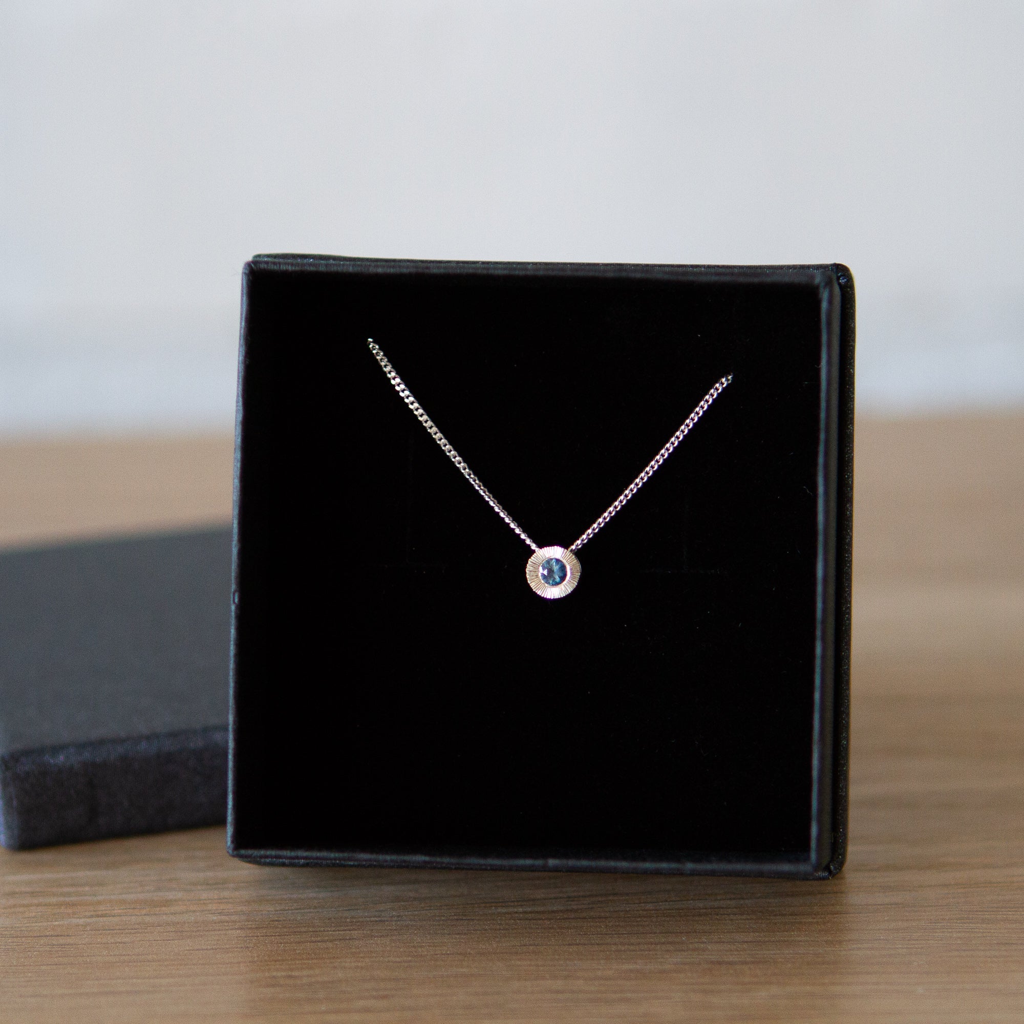 Sterling silver small aurora necklace with a blue Montana sapphire center in a gift box