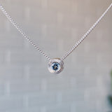 March birthstone sterling silver Aurora necklace with aquamarine center and engraved sunburst halo border.
