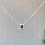 November birthstone sterling silver Aurora necklace with citrine center and engraved sunburst halo border.