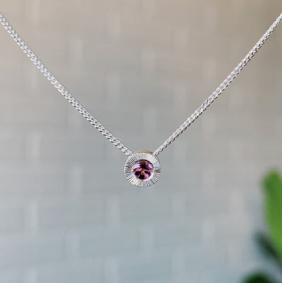 October birthstone sterling silver Aurora necklace with pink tourmalie center and engraved sunburst halo border.