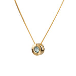 Side view 14k yellow gold Medium aurora necklace with a light teal Montana sapphire center on a white background