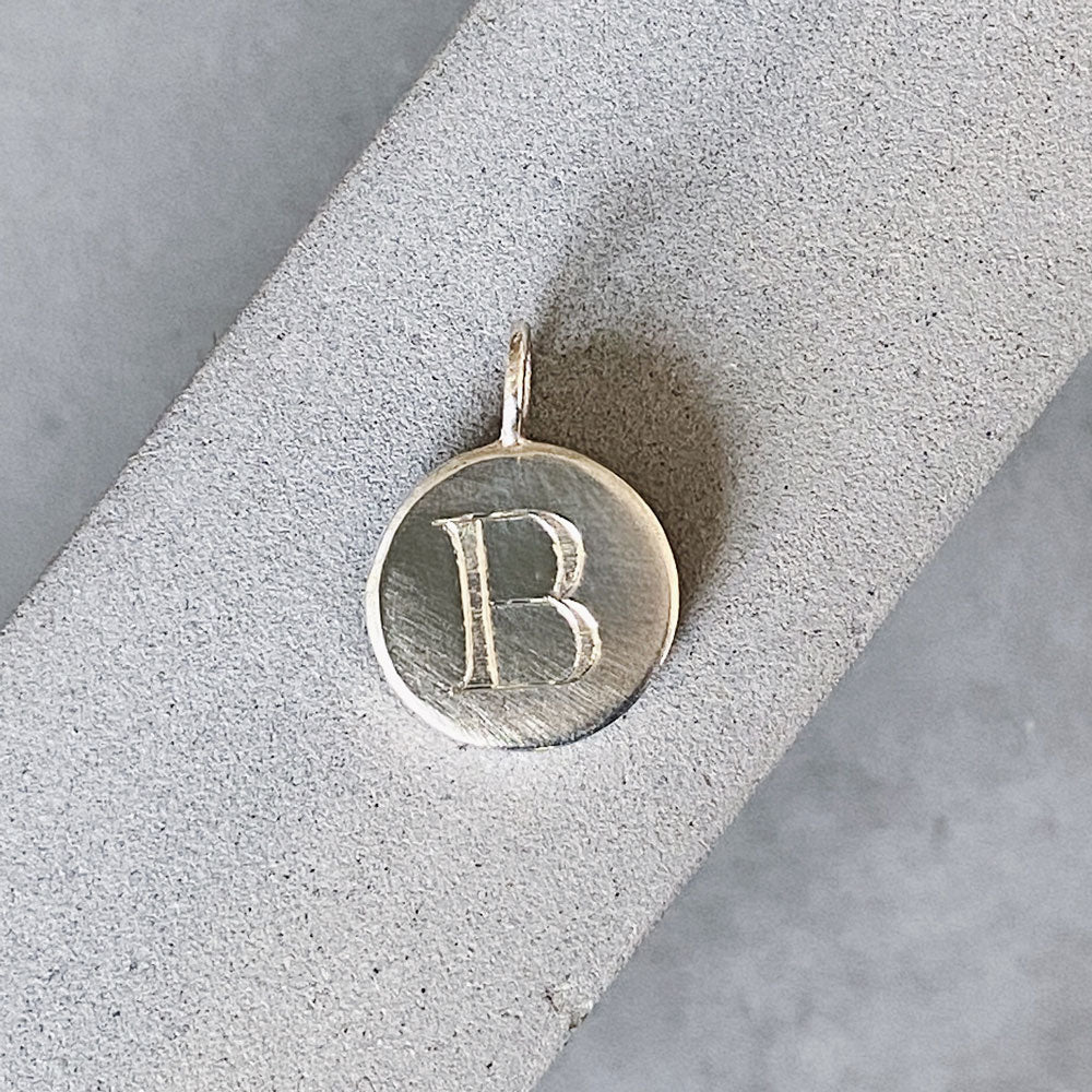 Sterling silver round pendant with an engraved block letter B