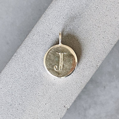 Sterling silver round pendant with an engraved block letter J