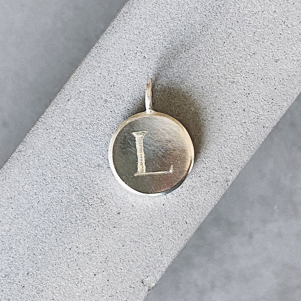 Sterling silver round pendant with an engraved block letter L