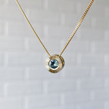 Side View 14k yellow gold Medium aurora necklace with a light teal Montana sapphire center in natural light