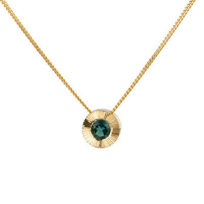 14k yellow gold medium Aurora necklace with a round teal green indicolite tourmaline center and engraved rays halo border on a white background