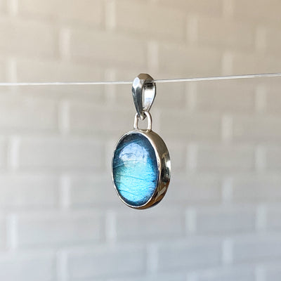 Smooth Oval Labradorite cabochon in a sterling silver bezel with a faceted bail alternate view
