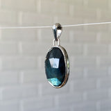 Side view of Large oval rose cut labradorite pendant crafted from sterling silver with a faceted silver bail