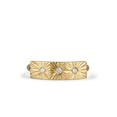 Yellow gold bar ring with three diamonds and a carved sunburst design around each by Corey Egan on a white background