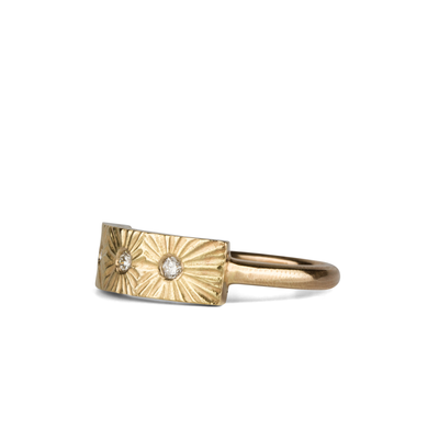 Yellow gold bar ring with three diamonds and a carved sunburst design around each by Corey Egan side view on a white background